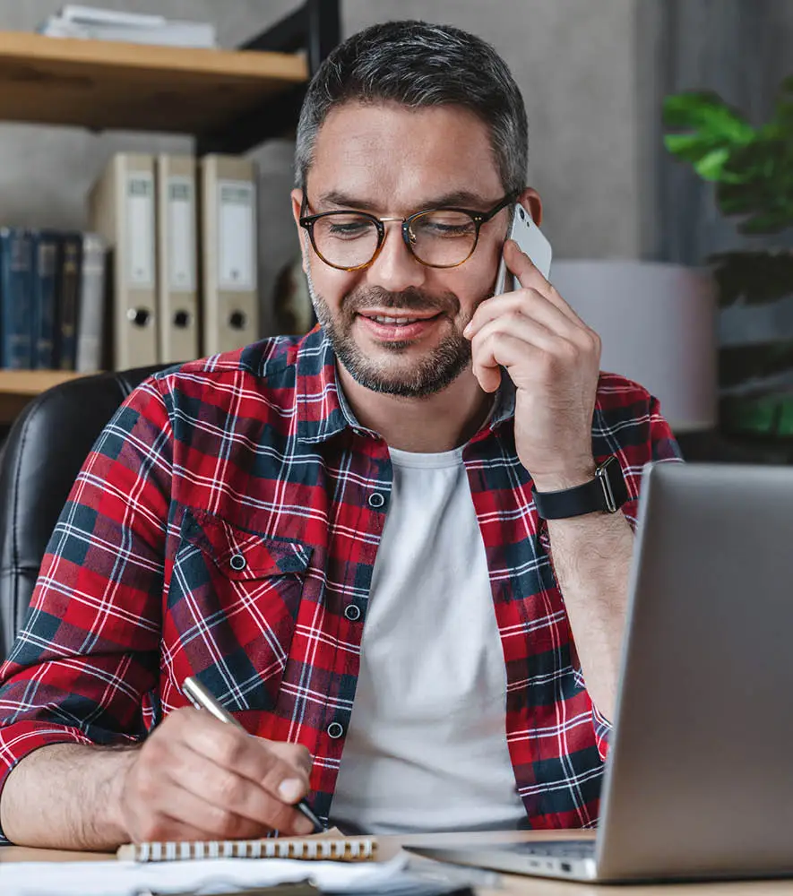 A happy middle age man speaking to a customer support executive on the phone