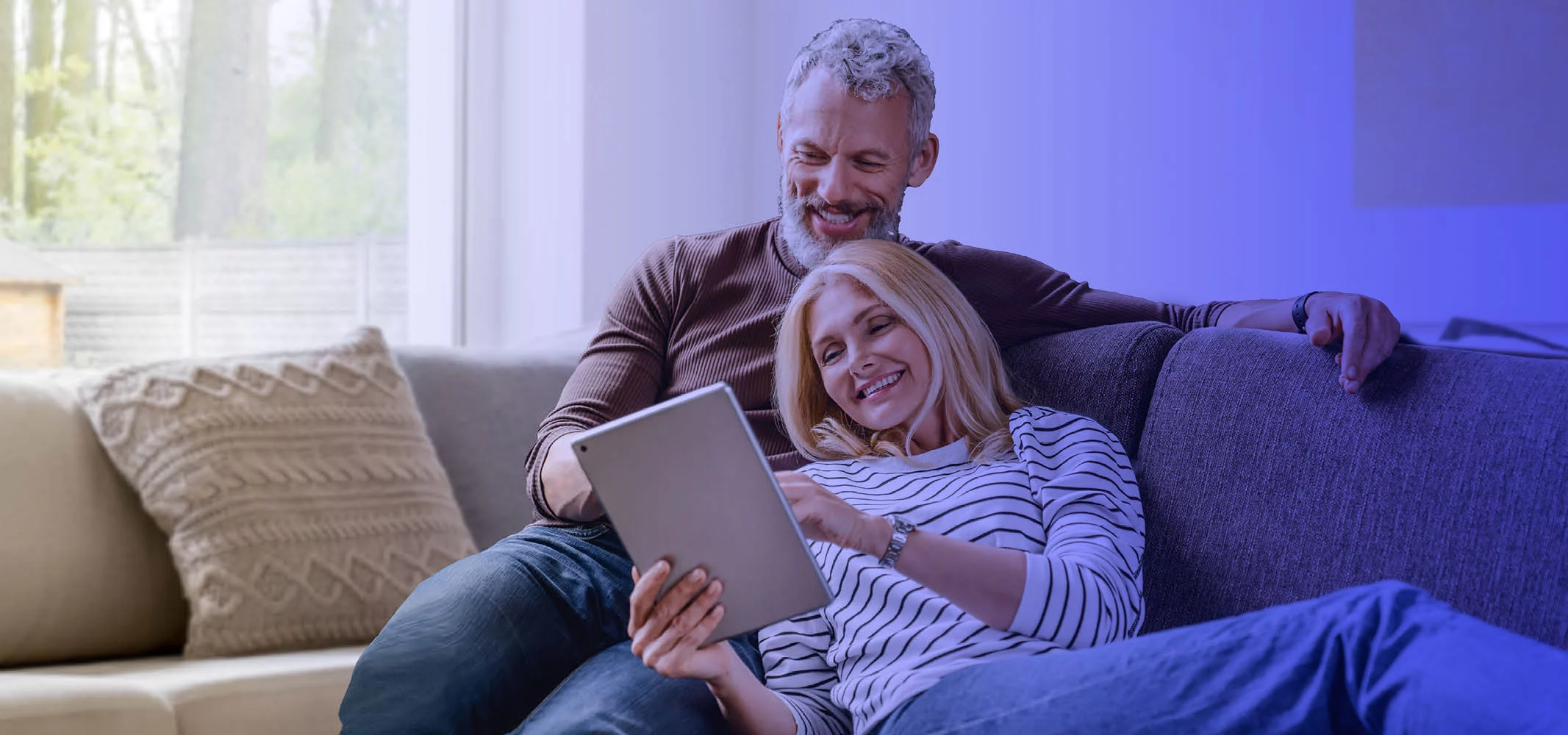 A middle age couple enjoying their time scrolling on the tablet and seraching for holiday destination