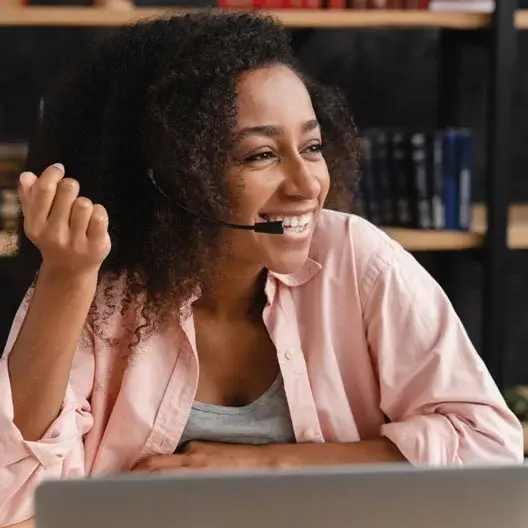 A happy call center agent speaking with the customer in a work from home set up