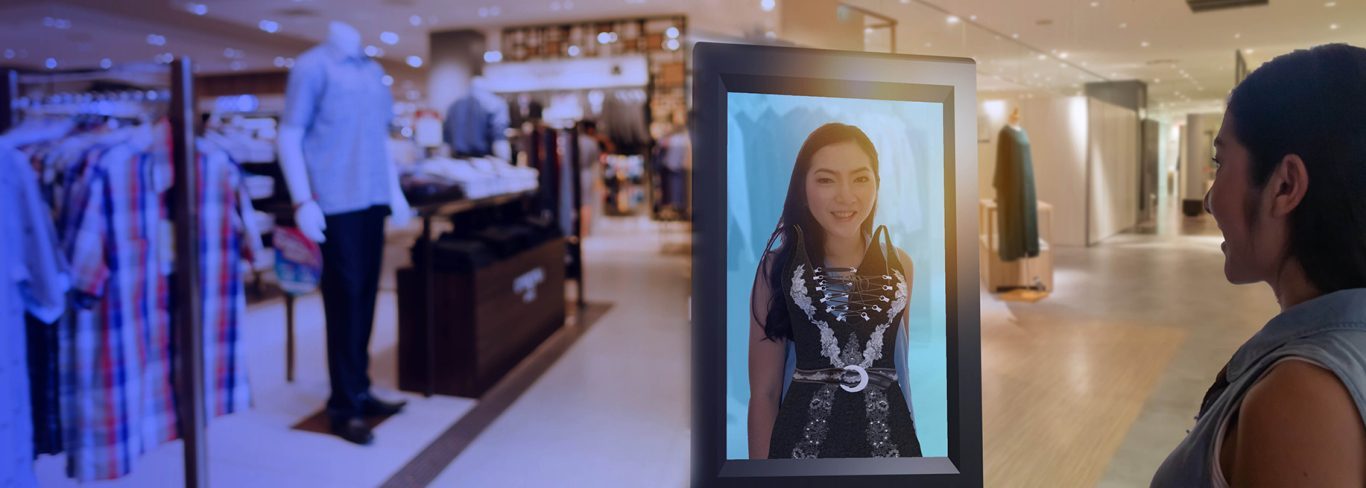 Excited lady using an augmented reality kiosk to buy a dress