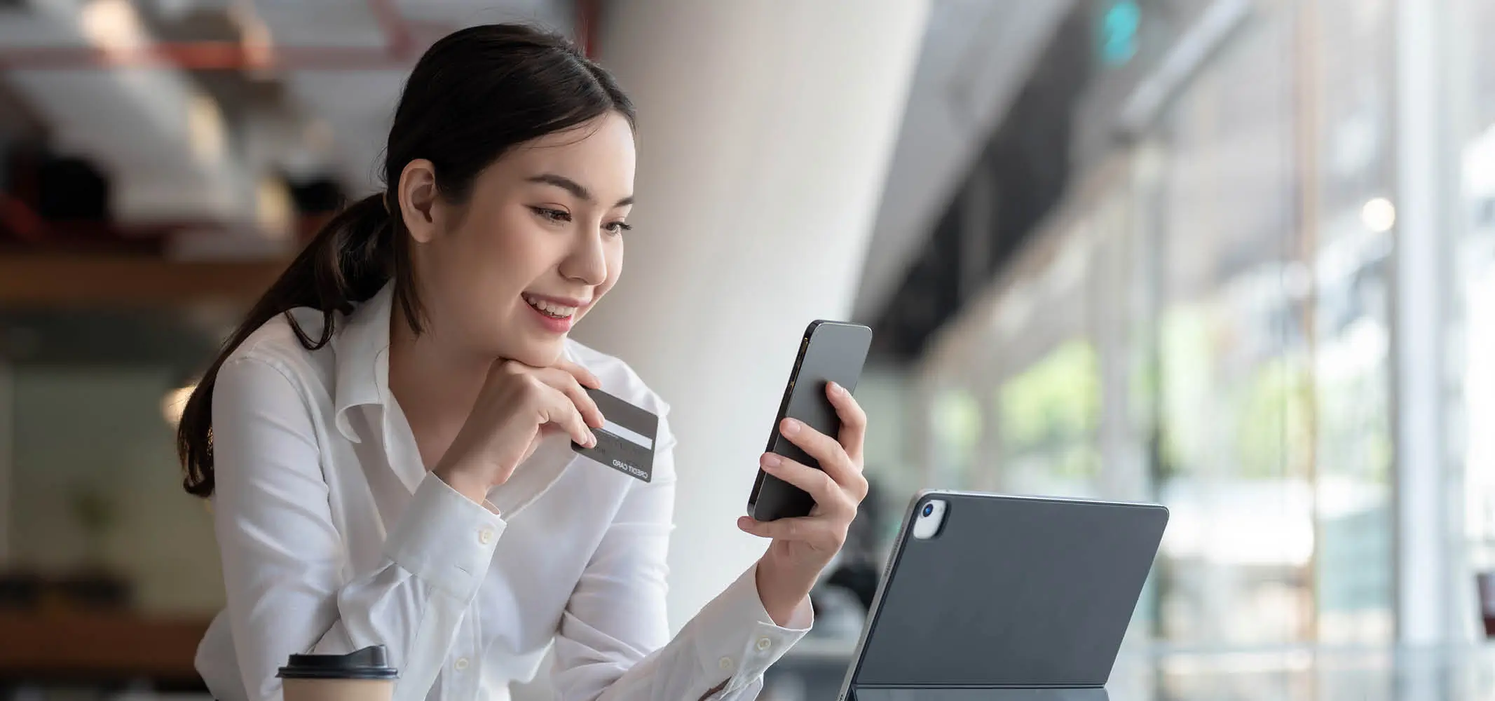 Happy woman using the e-banking services while interacting with a chatbot
