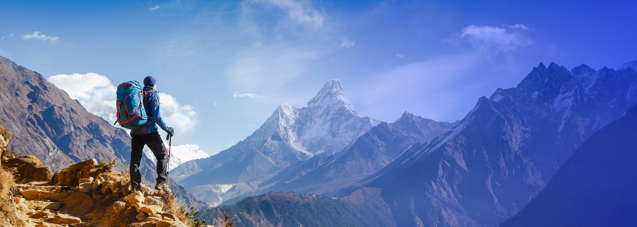 Mountaineer looking at snow covered mountains in the distance