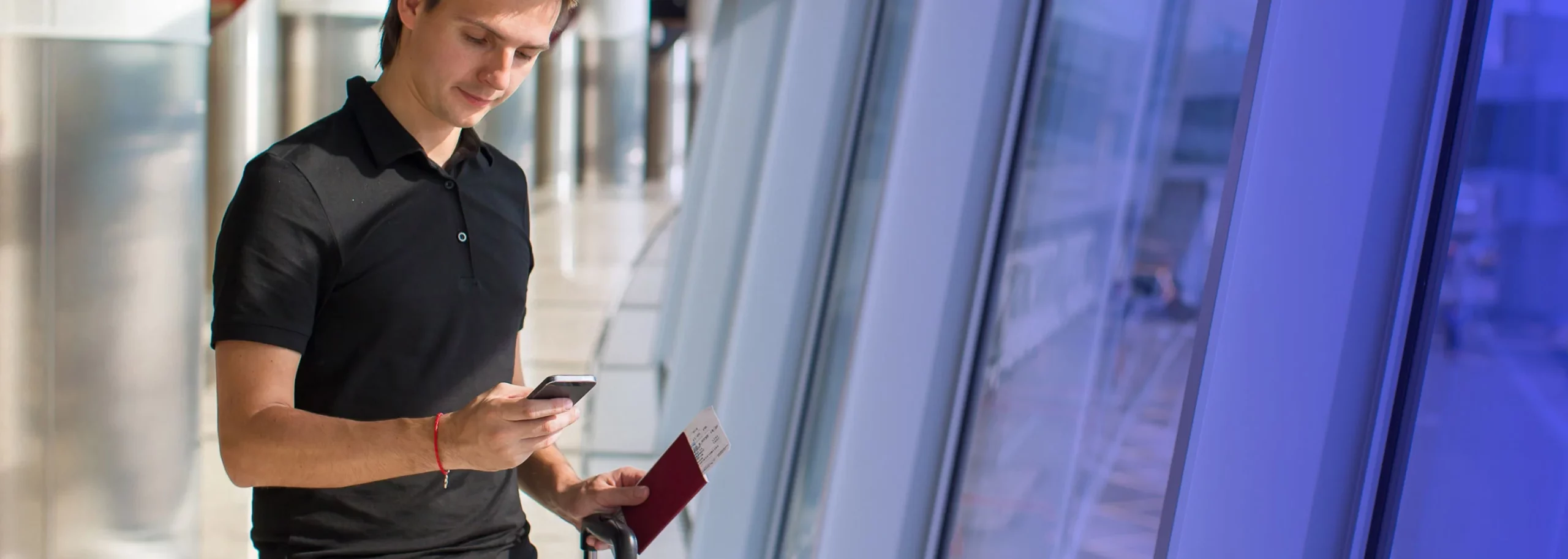 Traveler checking his hotel reservation through his cellphone at the airport