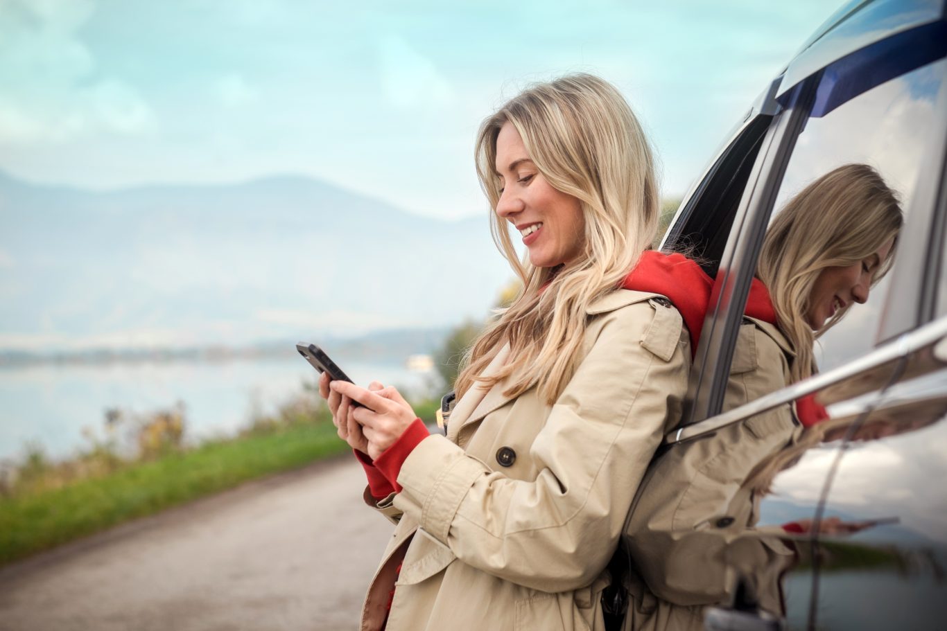 Young lady making travel plans on her phone